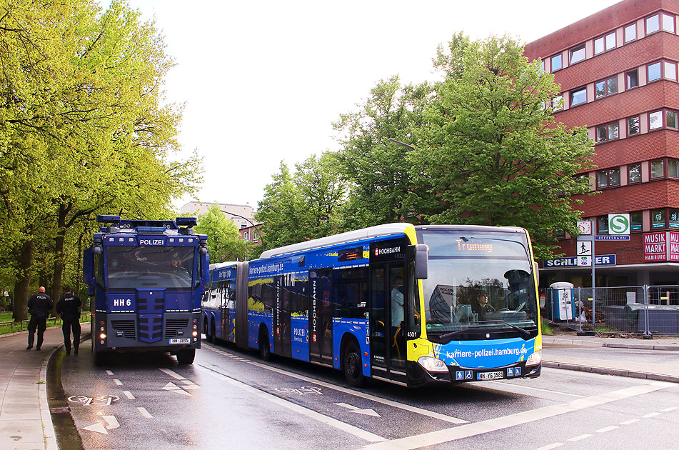 Ein Wasserwerfer der Hamburger Polizei und ein Hochbahn-Bus mit Werbung für die Hamburger Polizei an der Haltestelle S-Bahn Reeperbahn