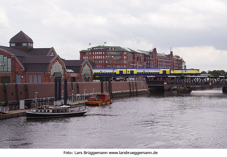 Die Oberhafenbrücke in Hamburg mit einem Metronom und einer Barkasse