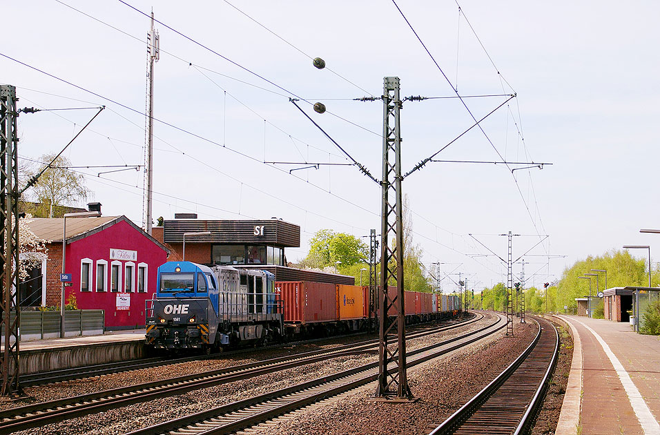 Eine G 2000 der OHE mit einem Containerzug im Bahnhof Stelle