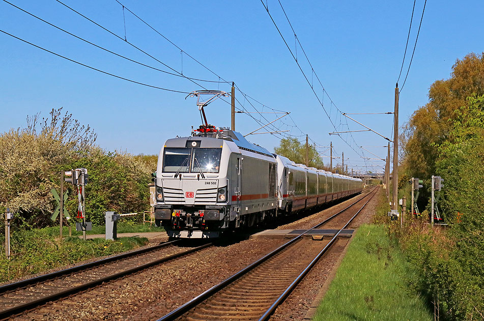 Eine Lok der Baureihe 248 mit einem ICE L im Bahnhof Krempe