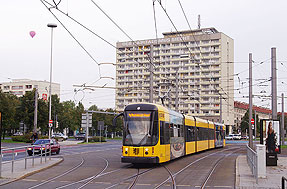 Im Hintergrund das markante Hochhaus Pirnaischer Platz: Straßenbahn Dresden - Haltestelle Pirnaischer Platz - Hochhaus - Der Sozialismus siegt - Der Kapitalismus siecht